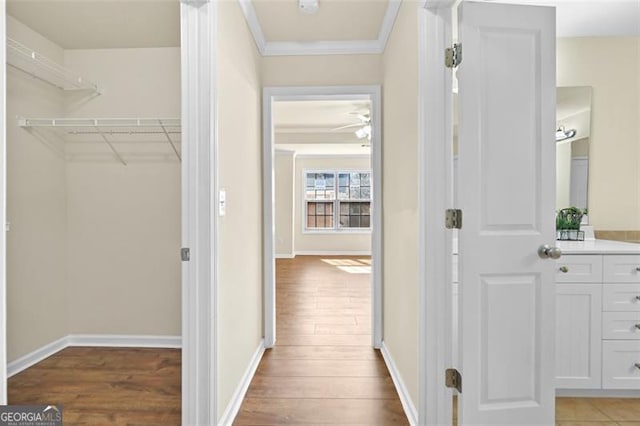 interior space with crown molding, baseboards, and wood finished floors