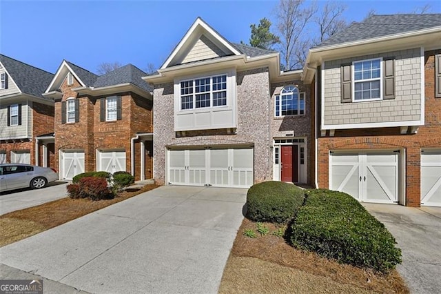 multi unit property featuring a garage, concrete driveway, and brick siding