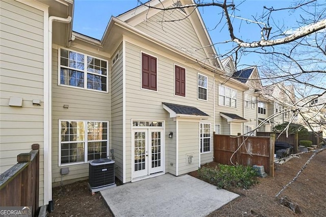 rear view of property with french doors, a patio area, fence, and central AC unit