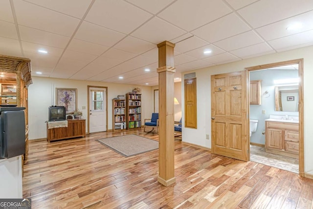 workout room featuring a paneled ceiling, recessed lighting, a sink, baseboards, and light wood-style floors