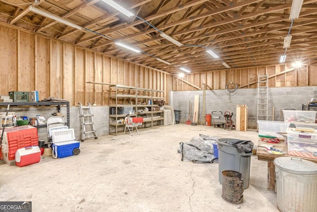 misc room featuring a garage and unfinished concrete floors