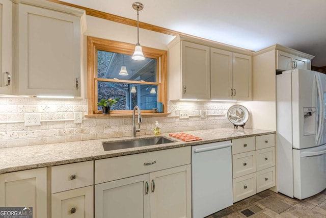 kitchen featuring light stone counters, white appliances, a sink, decorative backsplash, and decorative light fixtures