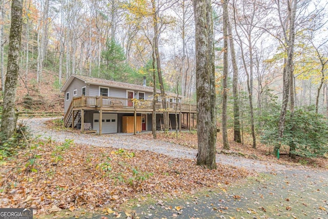 back of house with a garage, driveway, stairway, and a wooden deck