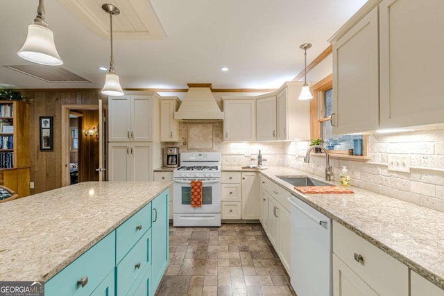 kitchen with white appliances, tasteful backsplash, decorative light fixtures, premium range hood, and a sink