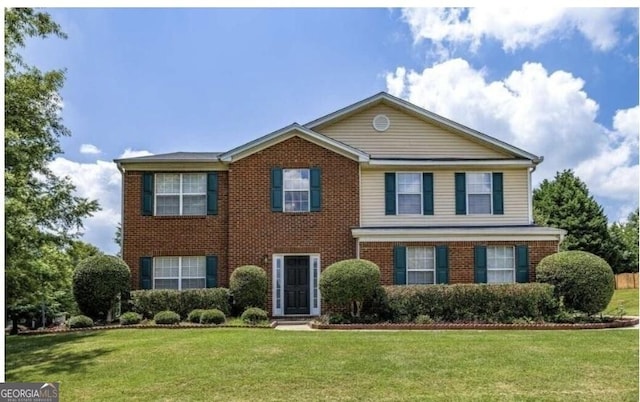 colonial inspired home featuring a front lawn and brick siding