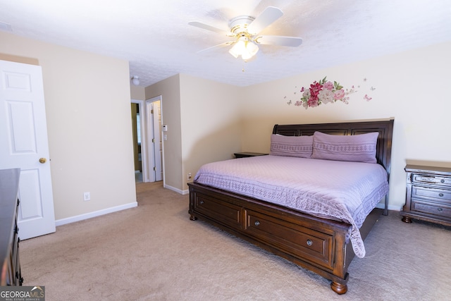 bedroom with a ceiling fan, baseboards, a textured ceiling, and light colored carpet