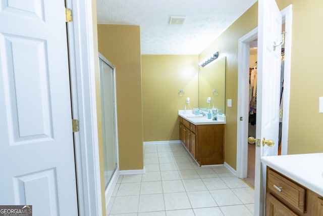 full bath with visible vents, a shower stall, vanity, a textured ceiling, and tile patterned flooring