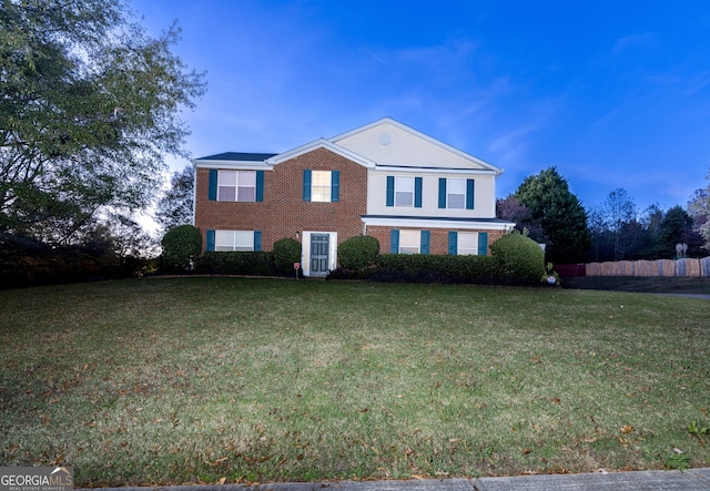 view of front facade featuring brick siding and a front yard