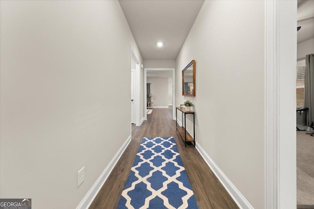 corridor featuring baseboards, dark wood finished floors, and recessed lighting