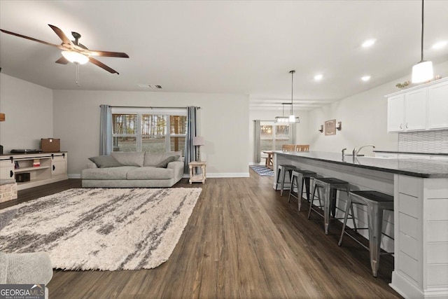 living room with dark wood-style floors, recessed lighting, baseboards, and a ceiling fan