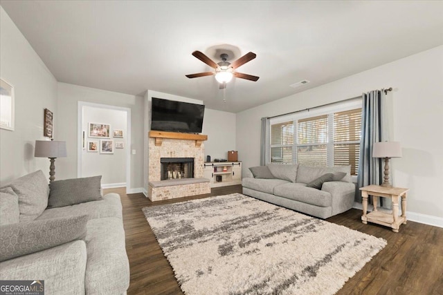 living area with dark wood-style floors, a fireplace, visible vents, a ceiling fan, and baseboards