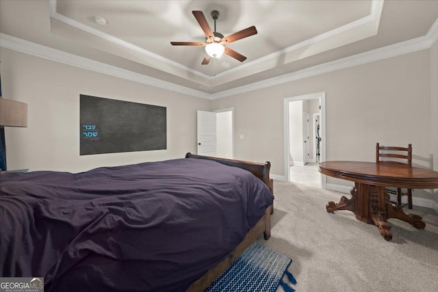 carpeted bedroom featuring ornamental molding, a raised ceiling, and baseboards