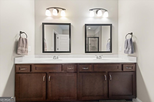 full bathroom featuring double vanity, a sink, and a shower stall