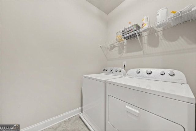 laundry room featuring laundry area, washing machine and clothes dryer, and baseboards