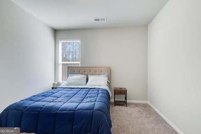 bedroom with visible vents, light carpet, and baseboards