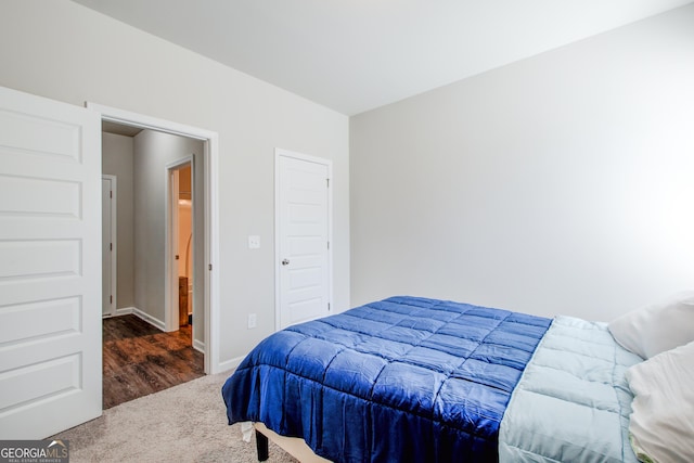 bedroom with dark colored carpet and baseboards