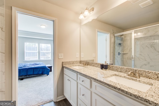 ensuite bathroom featuring double vanity, a marble finish shower, a sink, and ensuite bathroom