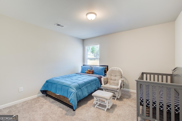 bedroom with light carpet, visible vents, and baseboards