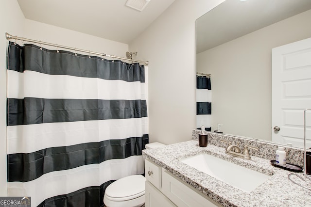 bathroom with visible vents, vanity, and toilet