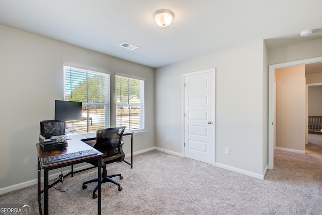 office featuring visible vents, light carpet, and baseboards