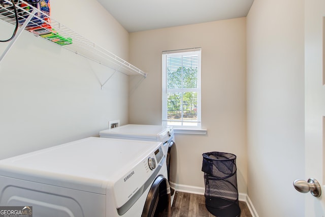 clothes washing area featuring washing machine and dryer, laundry area, baseboards, and dark wood-style flooring