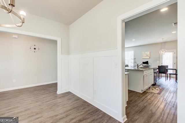 interior space with visible vents, wainscoting, dark wood-type flooring, a notable chandelier, and recessed lighting