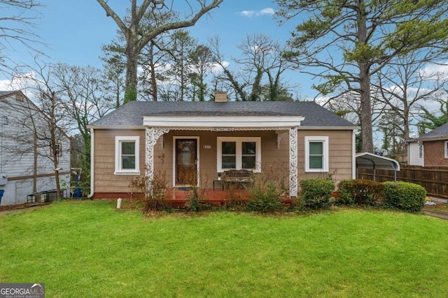 bungalow-style house with a carport, a front lawn, a chimney, and a porch