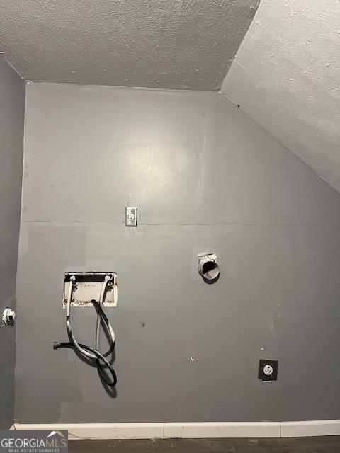 laundry room with hookup for an electric dryer and a textured ceiling