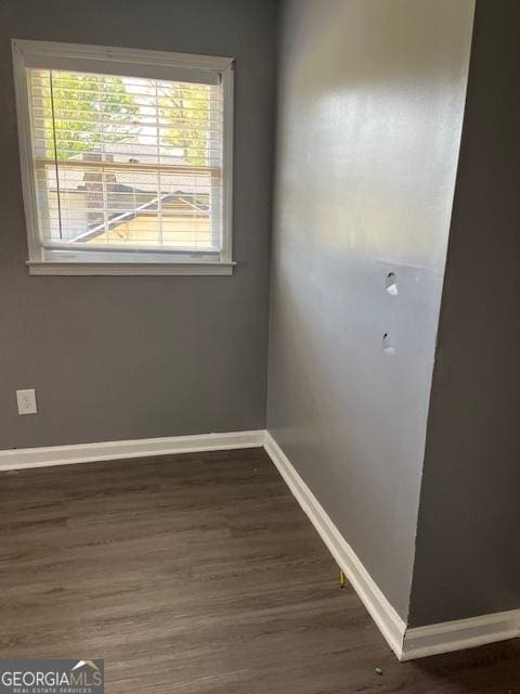 empty room featuring baseboards and wood finished floors