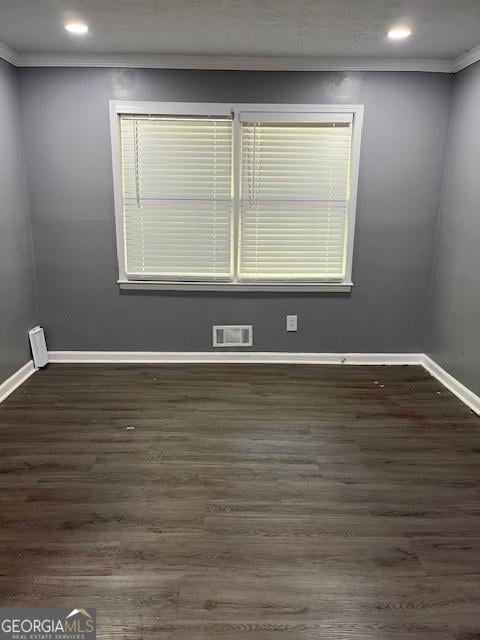 spare room with ornamental molding, dark wood-style floors, recessed lighting, and baseboards