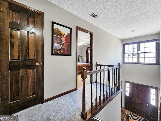 230 Mapledale Trl, Sharpsburg, GA 30277 - hallway with an upstairs landing, carpet, a chandelier, baseboards, and a textured ceiling
