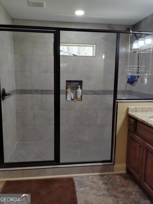 bathroom featuring a shower stall, visible vents, and vanity