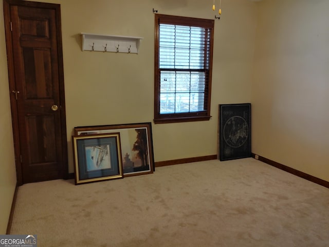 interior space with baseboards and light colored carpet