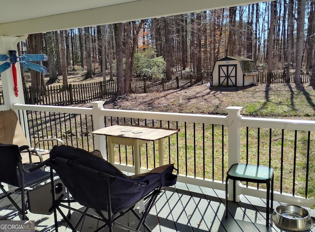 deck featuring an outbuilding, a shed, and a fenced backyard