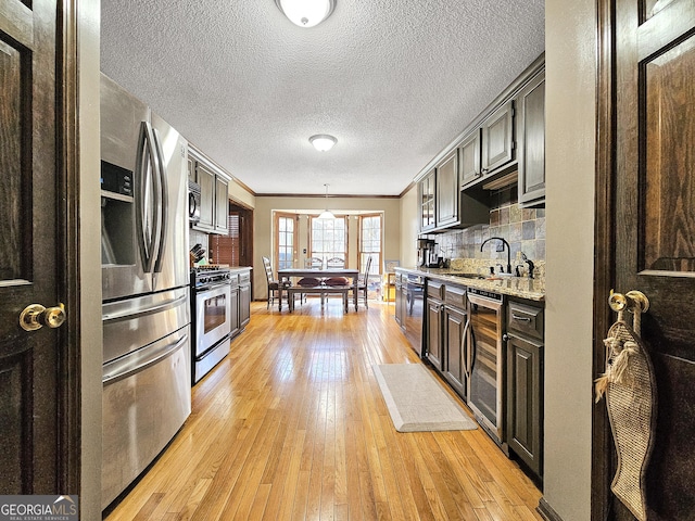 230 Mapledale Trl, Sharpsburg, GA 30277 - kitchen featuring beverage cooler, stainless steel appliances, a sink, light wood finished floors, and a textured ceiling