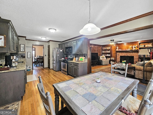 230 Mapledale Trl, Sharpsburg, GA 30277 - dining area featuring ornamental molding, a fireplace, light wood-style floors, ceiling fan, and a textured ceiling