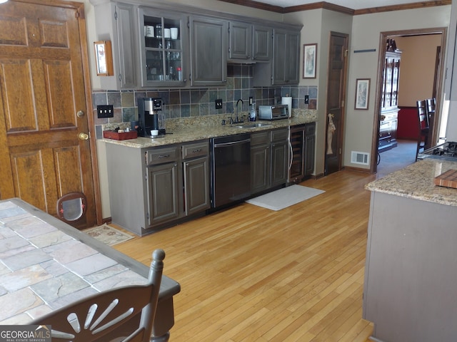 kitchen with visible vents, dishwasher, a sink, and light stone countertops