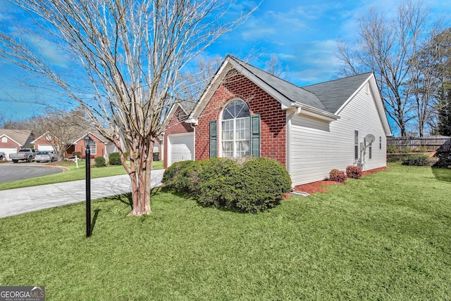 view of side of home with brick siding, a yard, fence, a garage, and driveway