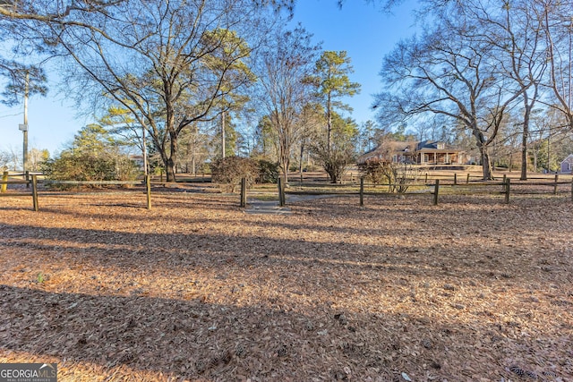 view of yard featuring a rural view and fence