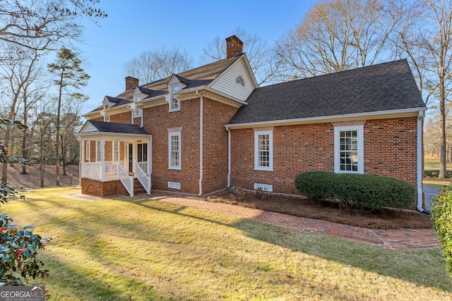 exterior space with a front yard, crawl space, brick siding, and a chimney