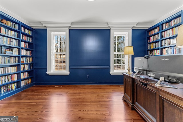 office space with bookshelves, ornamental molding, dark wood finished floors, and built in features