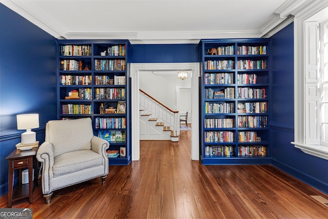 sitting room with built in features, visible vents, ornamental molding, and dark wood-style flooring