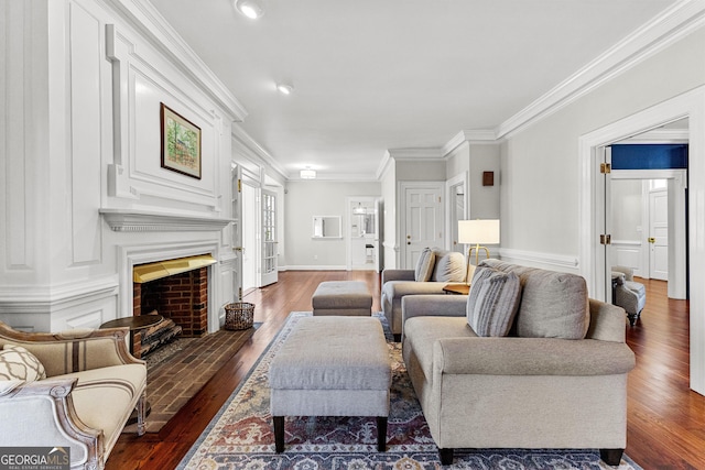 living room featuring baseboards, a fireplace with flush hearth, ornamental molding, and dark wood-style flooring