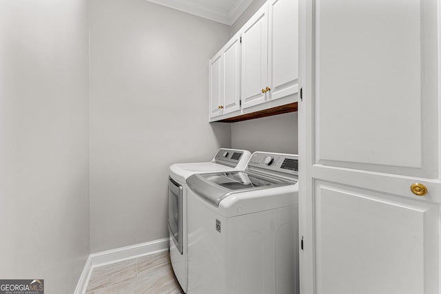washroom featuring crown molding, washing machine and dryer, cabinet space, and baseboards