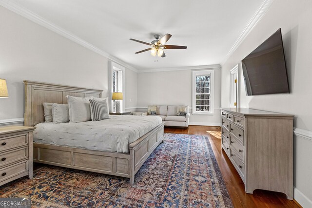 bedroom with dark wood-style flooring, crown molding, and baseboards
