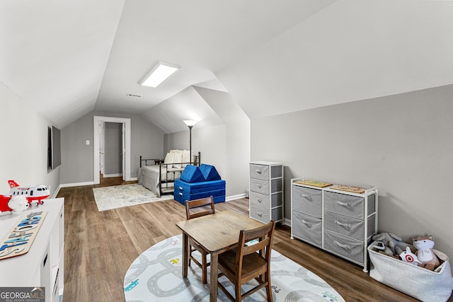 interior space featuring lofted ceiling, baseboards, and wood finished floors