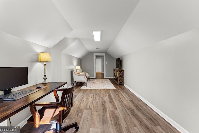 office space with lofted ceiling, wood finished floors, and baseboards