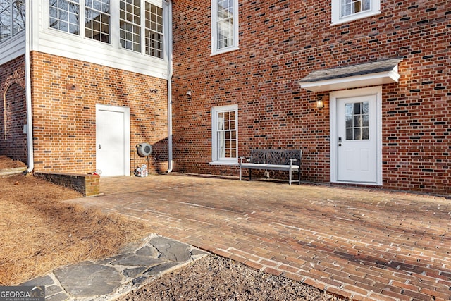 doorway to property with a patio and brick siding