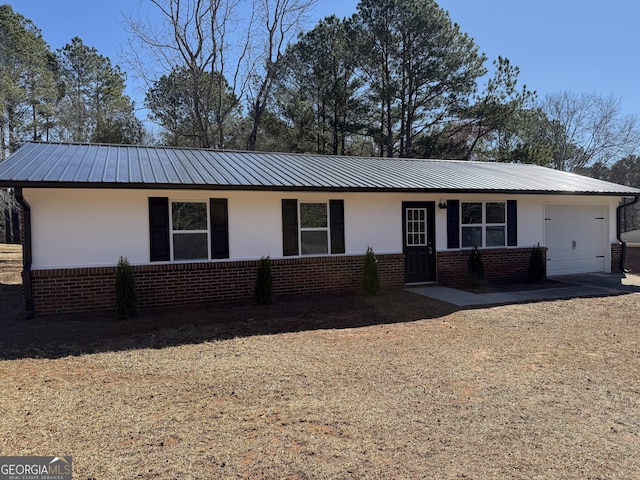 ranch-style house featuring a garage, metal roof, and brick siding