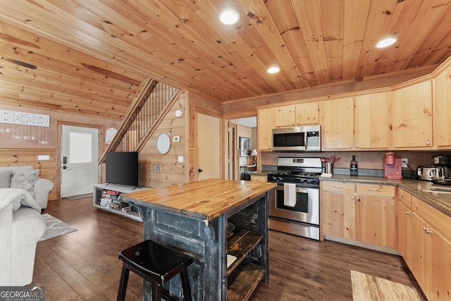 kitchen featuring stainless steel appliances, wooden counters, light brown cabinetry, dark wood-type flooring, and open floor plan